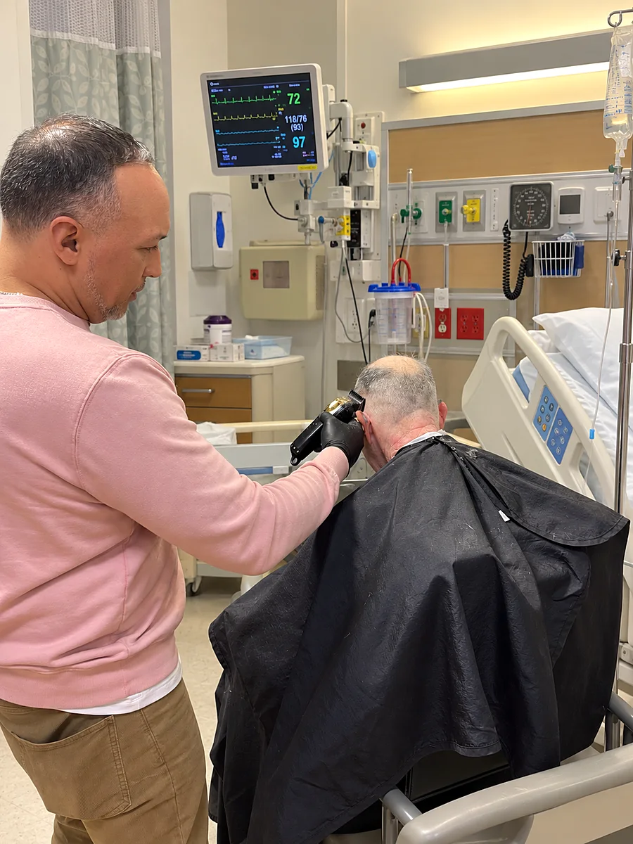Hair & Cuts barber giving a patient a haircut in a hospital room in New York City